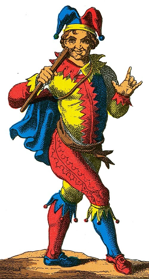 The Fool in a red, blue, and yellow costume, carrying a staff.
